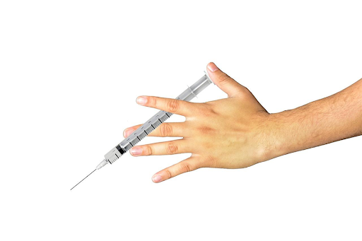 Une main tenant une seringue de vaccination sur un fond blanc.