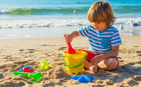 Enfant jouant avec un seau à sable sur la plage