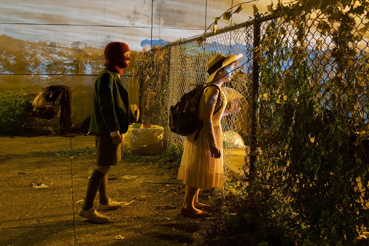 Des adolescents devant un grillage