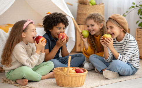 des enfants qui mangent chacun une pomme