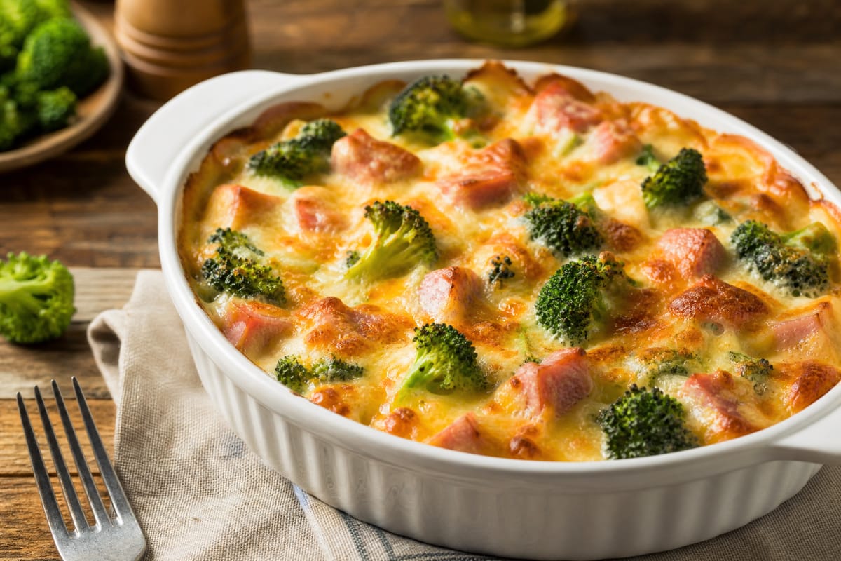 Gratin de brocoli, jambon et fromage doré au four dans un plat blanc.