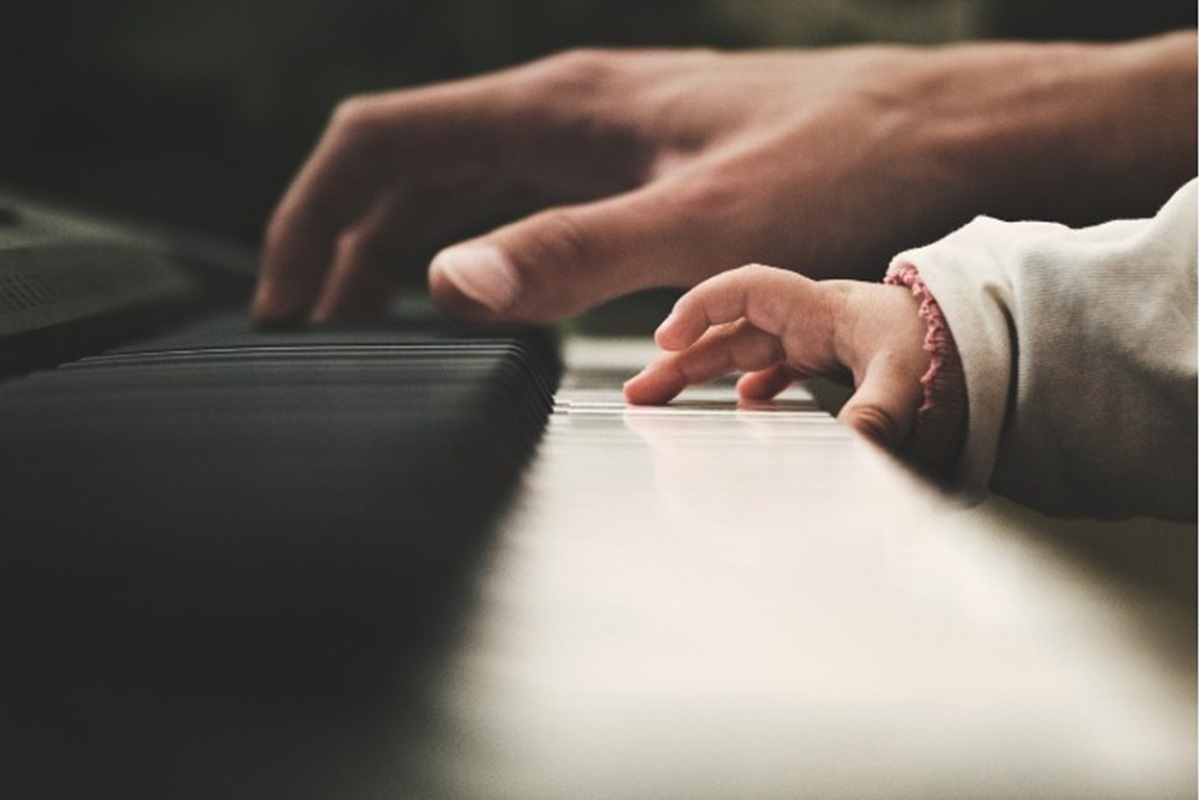 Un adulte et un enfant jouant au piano
