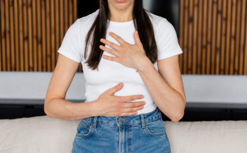 Femme avec les mains sur le corps, illustrant une crise d'angoisse.