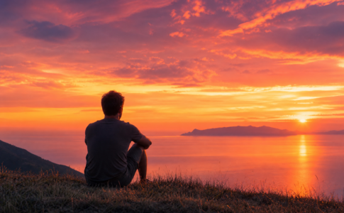Une personne observant un coucher de soleil lumineux.